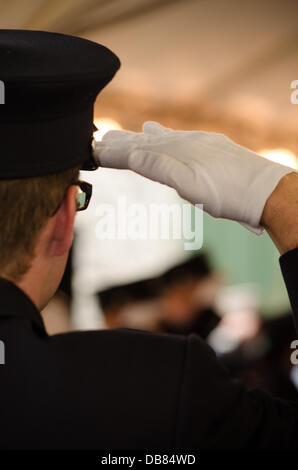 New York, USA. 24th July 2013. Paramedic renders salute to the fallen. On the one year anniversary of his death, the FDNY dedicated a memorial plaque to Paramedic Lenny Joyner. Paramedic Joyner was descending from a mountain climb at the Maroon Bells and was killed from a fall from at least 100 feet up Credit:  Michael Glenn/Alamy Live News Stock Photo