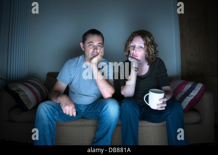 middle aged couple in a relationship watching television bored Stock Photo