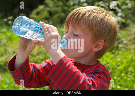 young boy drinking water from a bottle Stock Photo