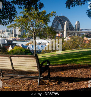 Bench under eucalyptus tree in Observatory Park with view over Sydney Harbour Bridge and Harbour The Rocks Sydney NSW Australia Stock Photo