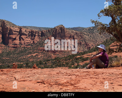 Woman tourist rests during a hike at Belll Rock, a balanced (both masculine and feminine) energy vortex, in Sedona, Arizona, USA Stock Photo