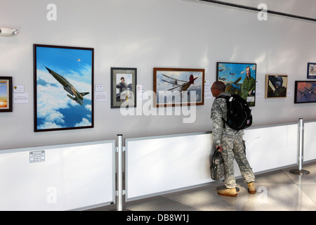 US Army soldier looking at art exhibition by American Society of Aviation Artists at Baltimore–Washington International Airport ( BWI ), Maryland, USA Stock Photo