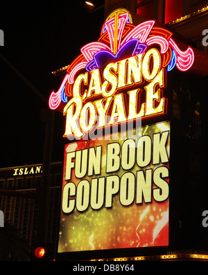 Night portrait electronic billboard '100X Odds on Craps!' below yellow pink neon sign, Casino Royale, The Strip, Las Vegas, USA Stock Photo