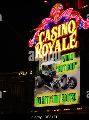 Night portrait electric billboard 'Win a Hot Rod on Hot Penny Slots' below yellow pink neon sign, Casino Royale, Las Vegas Strip Stock Photo