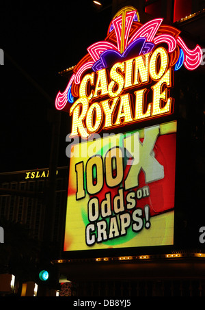 Night portrait electronic billboard '100X Odds on Craps!' below yellow pink neon sign, Casino Royale, The Strip, Las Vegas, USA Stock Photo