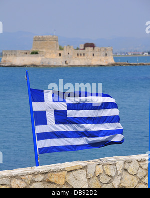 Greek flag flying in the coastal town of Nafplion with the Venetian Bourtzi Castle in the middle of the harbour in the background Peloponnese, Greece Stock Photo