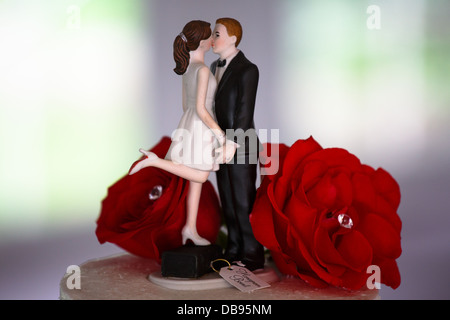 Bride and groom decoration on top of wedding cake with roses Stock Photo