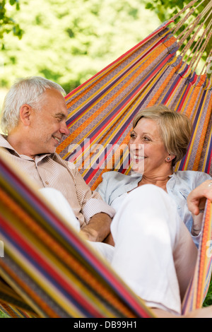 Happy elderly couple lying in hammock Stock Photo
