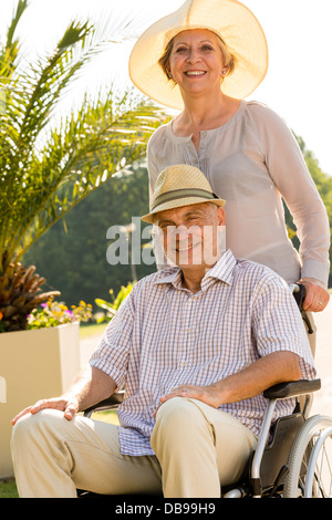 Senior woman with husband in wheelchair outdoors Stock Photo - Alamy