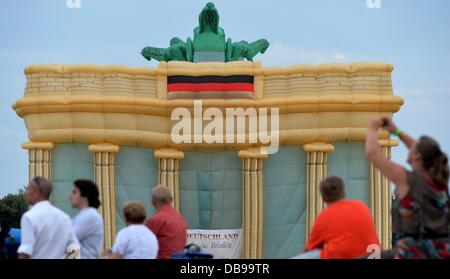 Leipzig, Germany. 25th July, 2013. A hot-air balloon shaped like the Brandeburg Gate is visible on a field at the beginning of the 19th Balloon Fiesta in Leipzig, Germany, 25 July 2013. Among the 35 hot-air balloons are seven uniquely designed examples, as well as some balloons from Russia, Sweden, Belgium and the Netherlands. The Balloon Fiesta is held until 28 July 2013. Photo: Hendrik Schmidt/dpa/Alamy Live News Stock Photo