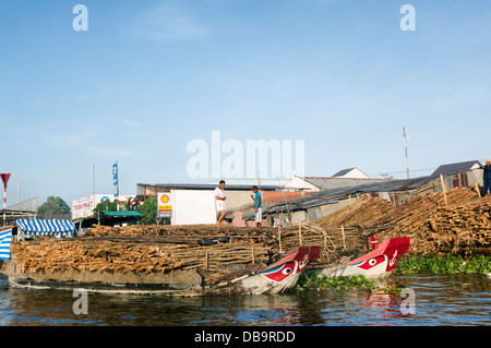 Can Tho, Mekong Delta, Vietnam - wooden boats loaded with timber. The boats have an eye on the hull which is traditional Stock Photo