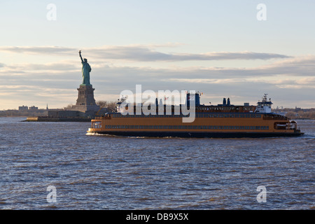 Staten Island Ferry cruises past the Statue of Liberty in New York City, NY Stock Photo