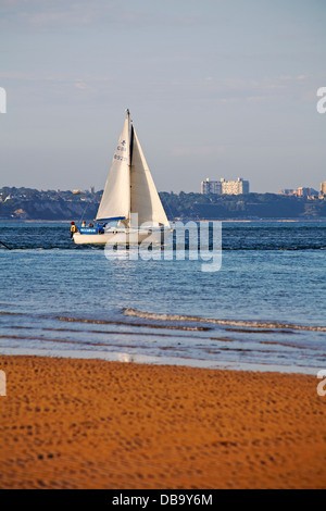 sailing yacht views from Studland beach with views of Bournemouth in the distance in July Stock Photo