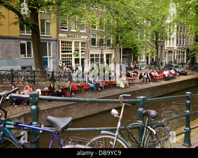 People relaxing along the Leliegracht canal in the city centre of Amsterdam, the Netherlands Stock Photo