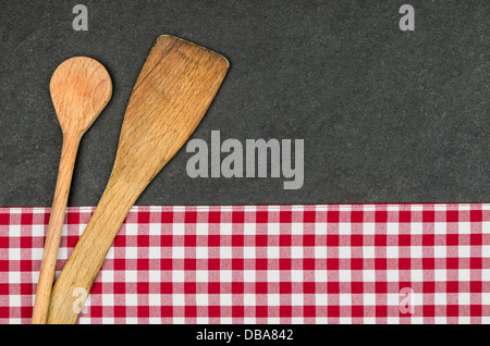 Wooden spoon on a slate plate with a red checkered tablecloth Stock Photo