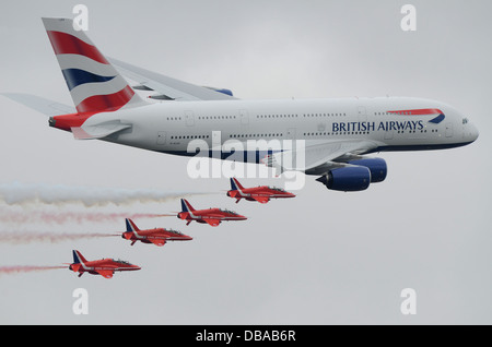 The famous Royal Air Force Red Arrows BAe Hawk jets in formation with British Airways first Airbus A380 'Super Jumbo' airliner jet plane. BA A380 Stock Photo