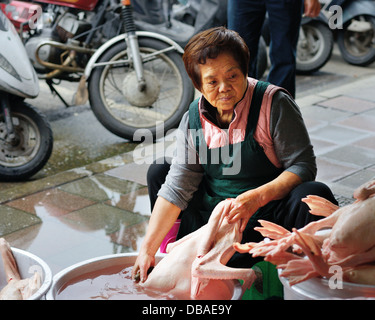 A woman prepares ducks on the street in Taipei, Taiwan. Stock Photo