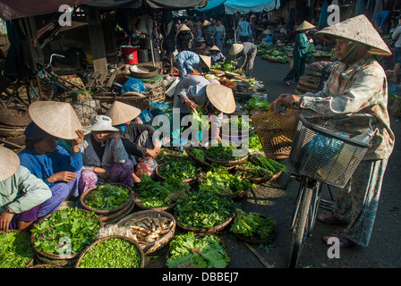 A group of unidentified women sells vegetables in an open market on January 10, 2008 in Hoi An, Vietnam. Stock Photo
