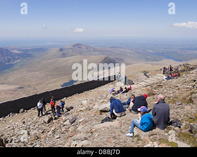 Scene with people resting on Mount Snowdon summit in Snowdonia National Park in summer. Llanberis, Gwynedd, North Wales, UK, Britain Stock Photo