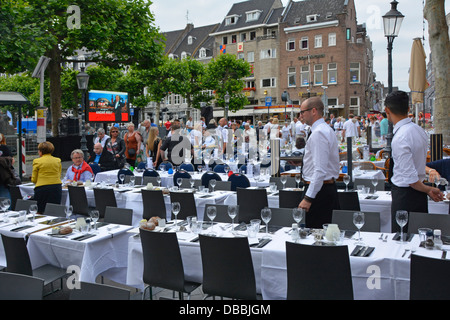 Maastricht assorted restaurant bars along Vrijthof Square pavement prepared tables await ticket holders for André Rieu outdoor evening music concert Stock Photo