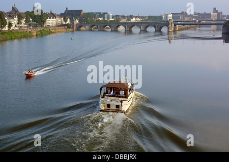 Maastricht early morning aerial view looking down on boats passing on the River Meuse urban landscape with bridge beyond Limburg Netherlands Europe EU Stock Photo
