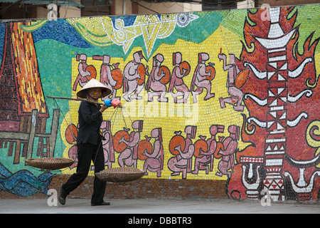 Woman walking past Hanoi Ceramic Mosaic Mural near Old Quarter of Hanoi, Vietnam, Southeast Asia Stock Photo