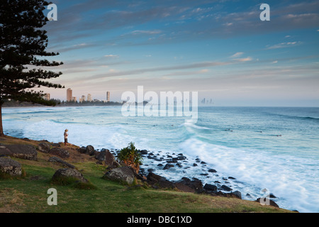 Man watching surfers at Burley Heads, at dawn. Gold Coast, Queensland, Australia Stock Photo