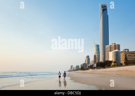 Tourists on beach with skyline at Surfers Paradise at dawn. Gold Coast, Queensland, Australia Stock Photo