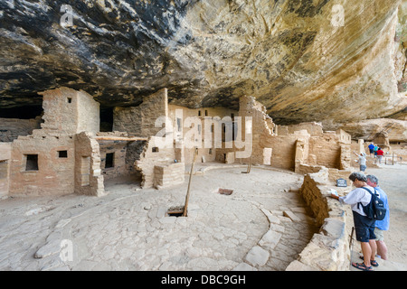 Tourists at Spruce Tree House ruins, ancient Anasazi pueblo dwellings, Mesa Verde National Park, Cortez, Colorado, USA. Cliff dwelling. Stock Photo