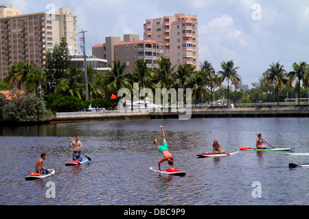 Fort Ft. Lauderdale Florida,Las Olas Boulevard,paddleboarding,adult adults man men male,adult,adults,woman women female lady,doing handstand,water,vis Stock Photo
