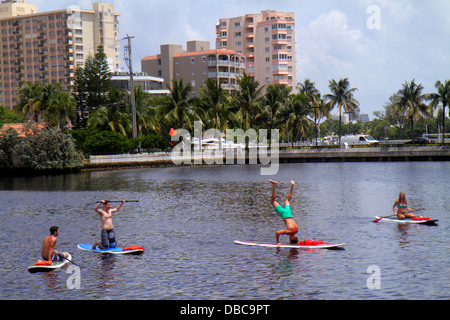 Fort Ft. Lauderdale Florida,Las Olas Boulevard,paddleboarding,man men male,adult,adults,woman female women,doing headstand,water,looking FL130720188 Stock Photo