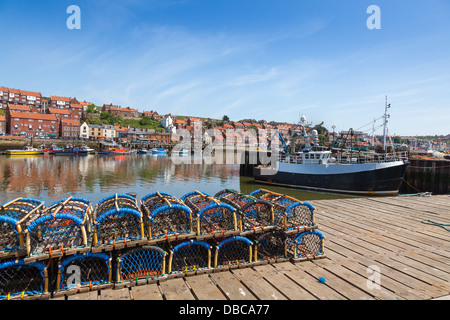 Whitby fishing harbor with lobster pots lining the quay.