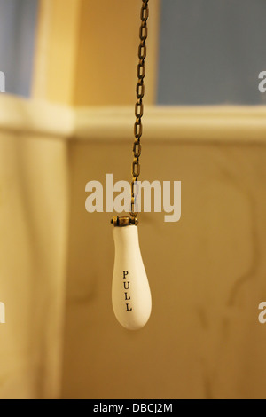 An old fashioned pull chain flusher for an old toilet. Stock Photo