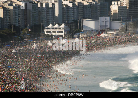 Copacabana Beach, Rio de Janeiro, Brazil. 27th July 2013. Pilgrims gather since early morning for the Campus Fidei vigil of the World Youth Day 2013. The main altar seen in the background was used by Pope Francis to preside ceremonies. Credit:  Maria Adelaide Silva/Alamy Live News Stock Photo