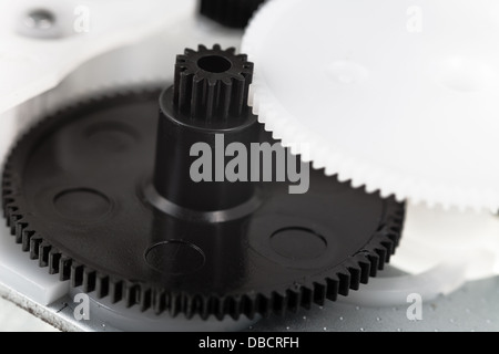 white and black plastic gears wheels close up Stock Photo