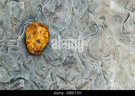 Red Ochre rock on eroded sandstone. Northumberland Coastline, England Stock Photo