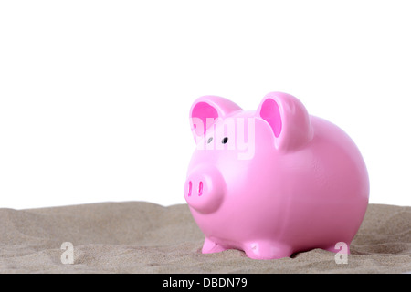 concept of holiday saving piggy bank in sand isolated on white Stock Photo