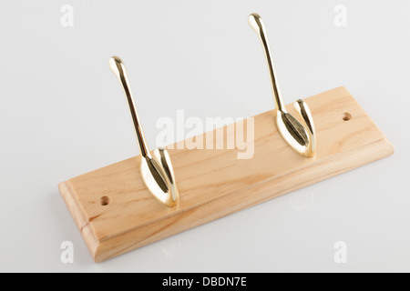 Double brass effect coat hanger on a pine wooden base Stock Photo