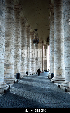 A priest through Bernini's colonnade in St. Peter's Square at the Vatican, Rome Stock Photo