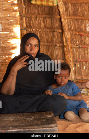 Inside Tuareg tent made from woven mats. The village 'queen'  in the home of her married daughter with her grand daughter. Mali Stock Photo