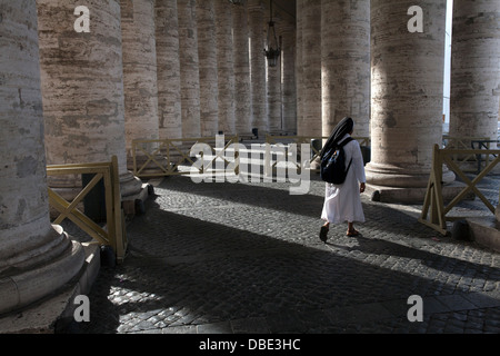 A nuns through Bernini's colonnade in St. Peter's Square at the Vatican, Rome Stock Photo