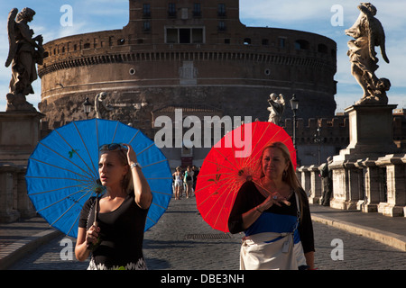 Rome. Several tourists walk across the bridge of Sant 'Angelo with the castle in the background Stock Photo