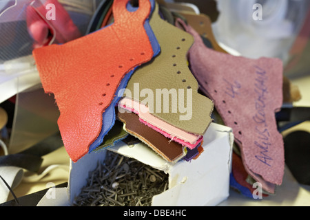 Swatches of leather samples, ribbon and nails for shoe making. Stock Photo