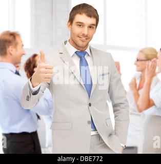 businessman showing thumbs up in office Stock Photo