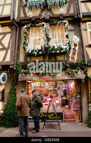 France, Alsace, Colmar. Christmas decorations on typical historic half-timbered butcher shop. Stock Photo
