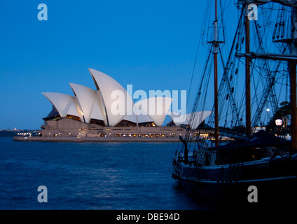 Sydney Opera House and historic tall ship at night / twilight / dusk from Campbells Cove Sydney New South Wales NSW Australia Stock Photo