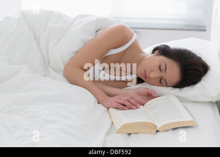 Mixed race woman asleep in bed Stock Photo