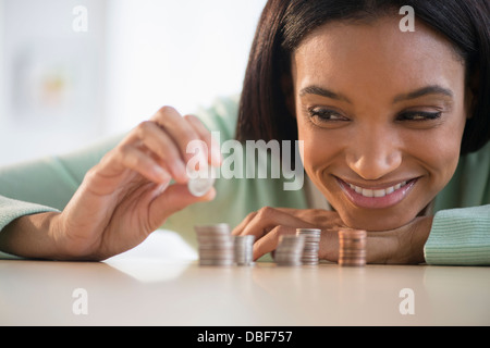 Mixed race woman stacking coins Stock Photo