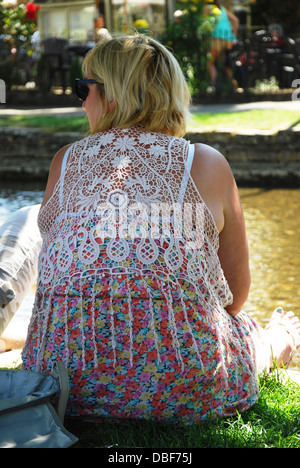 Tourist on banks of River Windrush, Bourton on the Water Gloucestershire England UK Stock Photo