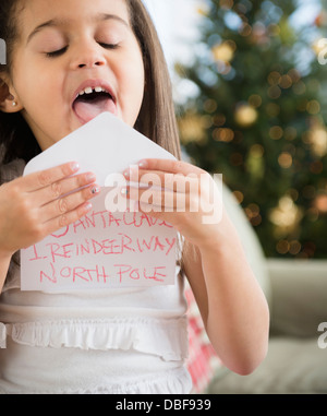 Hispanic girl sealing envelope for Santa Stock Photo